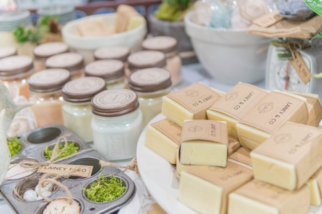 mesa com potes de cosmético branco e sabonetes na cor envoltos em papel kraft artesanal